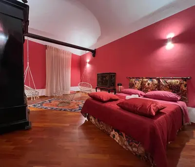 two beds in a red room with red walls at Le Radici casa vacanze in Palermo