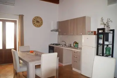 a kitchen with a table and a white refrigerator at Vecchio Cortile Home Holidays in Palermo