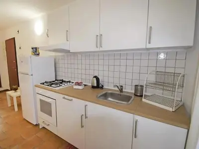 a kitchen with white cabinets and a sink and a stove at Vecchio Cortile Home Holidays in Palermo