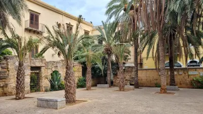 a group of palm trees in front of a building at 2 Sicilie Rooms and Suite in Centro in Palermo
