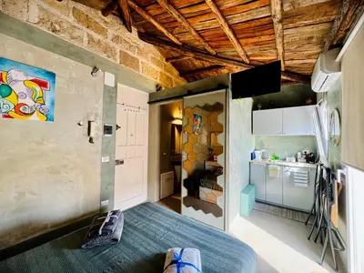 a small room with a bed and a kitchen at A Nicuzza in Palermo