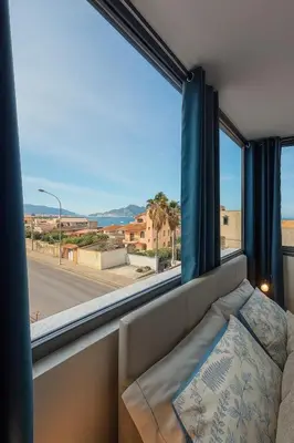 a couch in front of a window with a view of a street at Marine Case Vacanze in Palermo