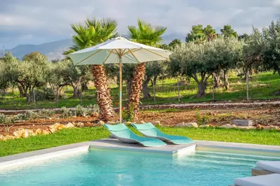 a pair of shoes and an umbrella next to a pool at Villa Majestatis in Scopello