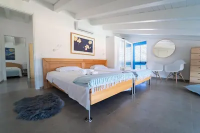 a bedroom with a large bed and a table and chairs at Villa Majestatis in Scopello