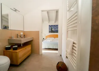 a bathroom with a bedroom with a bed and a sink at Villa Majestatis in Scopello