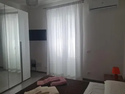 a bedroom with a bed and a large window at Casetta Bella Nonna Rosetta in Mondello