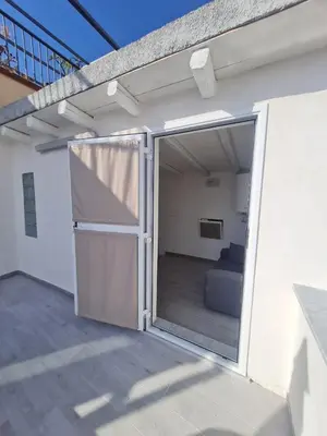 a sliding glass door to a patio with a couch at Casetta Bella Nonna Rosetta in Mondello