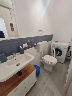 a bathroom with a sink and a toilet and a washing machine at Casetta Bella Nonna Rosetta in Mondello