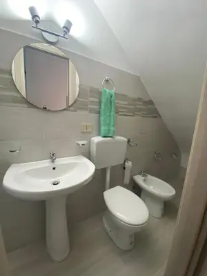 a bathroom with a sink and a toilet and a mirror at La casetta del sole in Castellammare del Golfo
