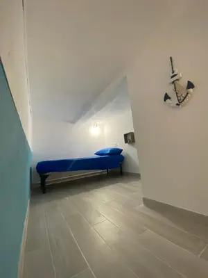 a small room with a blue bed in a wall at La casetta del sole in Castellammare del Golfo