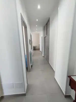 a hallway with white walls and a white tile floor at GiErre Apartment in Termini Imerese