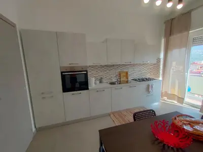 a kitchen with white cabinets and a table and a window at GiErre Apartment in Termini Imerese