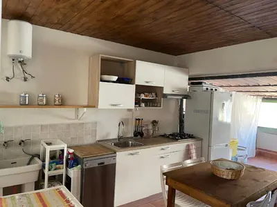 a kitchen with white cabinets and a wooden table at Casa Vacanza Sicilia Dolce Mare in Balestrate