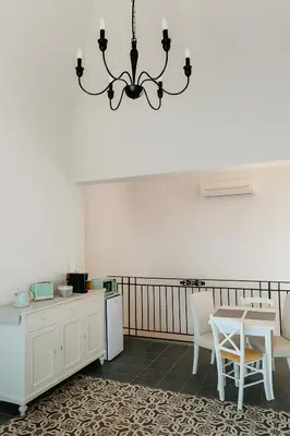 a kitchen with white cabinets and a chandelier at Villa Bona in Termini Imerese