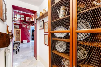 a room with a display cabinet filled with plates at La Dimora del Conte, immersa nel verde in centro città in Palermo
