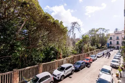 a row of cars parked on the side of a street at La Dimora del Conte, immersa nel verde in centro città in Palermo