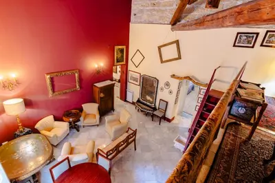 a living room with red walls and a staircase at La Dimora del Conte, immersa nel verde in centro città in Palermo
