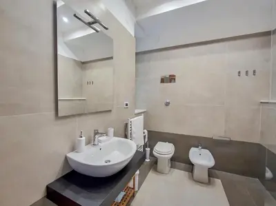 a bathroom with a sink and a toilet and a mirror at Annacati House Centro Storico in Palermo