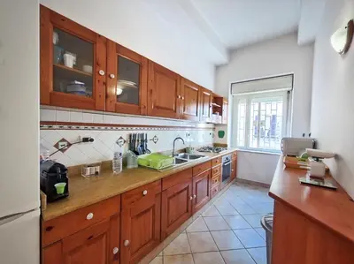 a kitchen with wooden cabinets and a sink at Annacati House Centro Storico in Palermo
