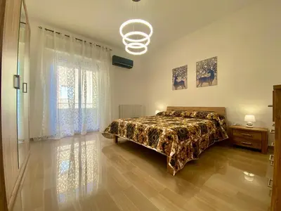 a bedroom with a bed and a large window at Alka Home, 7 km dal mare in Alcamo