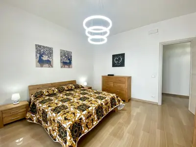 a large bedroom with a bed and a chandelier at Alka Home, 7 km dal mare in Alcamo