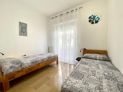 a bedroom with two beds and a window at Alka Home, 7 km dal mare in Alcamo