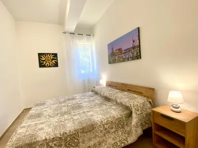 a bedroom with two beds and a lamp on a table at Alka Home, 7 km dal mare in Alcamo