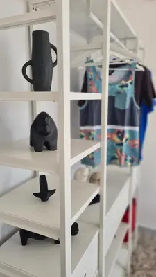 a white closet shelving unit with a helmet on it at Àrima Mondello Apartment in Mondello