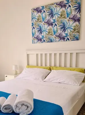 a bedroom with a bed with towels on it at Àrima Mondello Apartment in Mondello