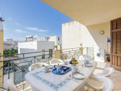 a white table and chairs on a balcony at Apartment Giardini Gaia by Interhome in San Vito lo Capo