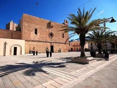 a large brick building with a palm tree in front of it at Apartment Giardini Gaia by Interhome in San Vito lo Capo