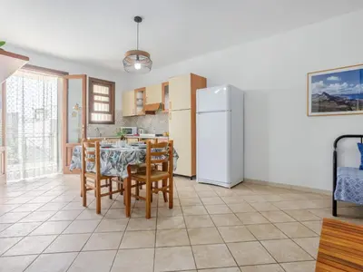 a kitchen and dining room with a table and a refrigerator at Apartment Giardini Gaia by Interhome in San Vito lo Capo