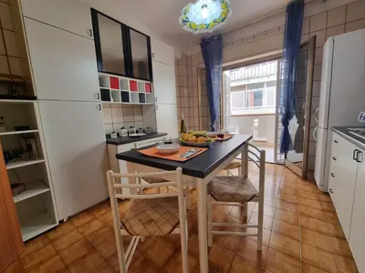 a kitchen with a table and chairs and a refrigerator at Lo Scorcio sul Mare by Holiday World in Isola delle Femmine