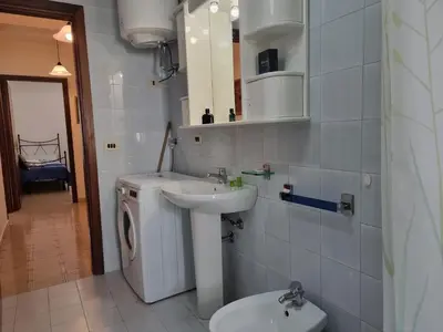 a bathroom with a sink and a washing machine at Lo Scorcio sul Mare by Holiday World in Isola delle Femmine