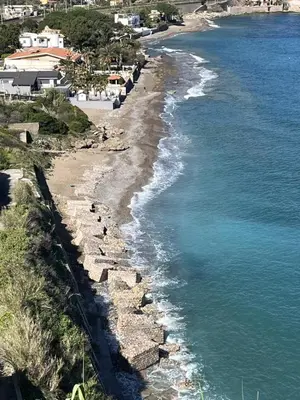 a beach with rocks and the ocean and houses at Villa Simo in Altavilla Milicia