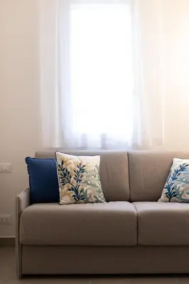 a couch with pillows sitting in front of a window at Casa vacanze Marinaro in Castellammare del Golfo