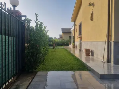 a white pergola with a bench on a patio at Magnolia in Campofelice di Roccella