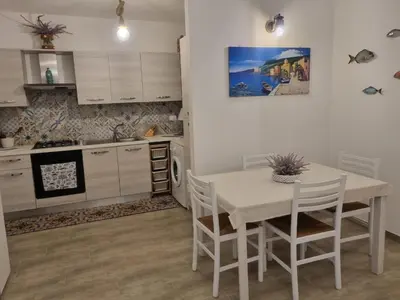 a kitchen with a table and chairs in a room at Magnolia in Campofelice di Roccella