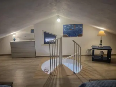 a room with a spiral staircase in a bedroom at Magnolia in Campofelice di Roccella