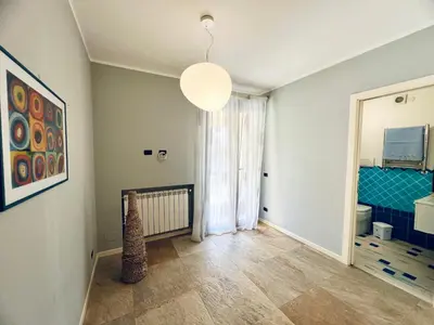 a living room with a large window and a bathroom at Rosa di Mare in Capaci