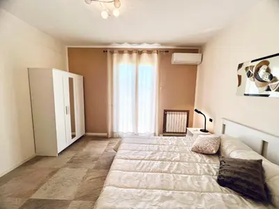 a bedroom with a large bed and a large window at Rosa di Mare in Capaci