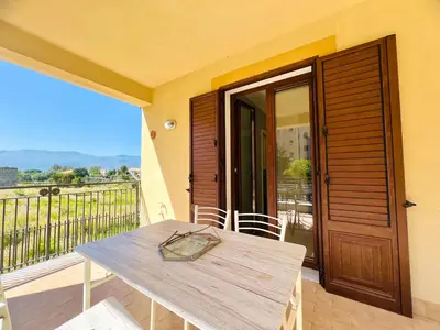 a table and chairs on a balcony with a door at Rosa di Mare in Capaci