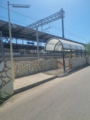 a train station with a stone wall next to a street at Blu horizon in Campofelice di Roccella