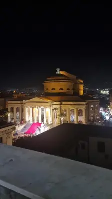 a large building at night with a pink umbrella at Le Gemme di Cavour Luxury Rooms in Palermo