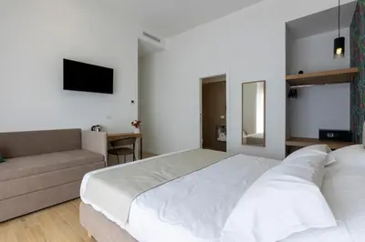 a bedroom with a large white bed and a couch at Le Gemme di Cavour Luxury Rooms in Palermo
