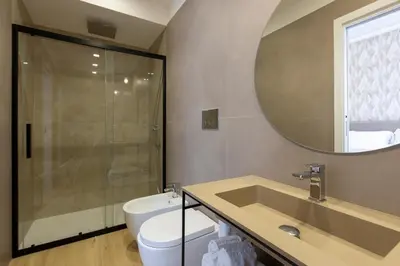 a bathroom with a toilet and a sink and a mirror at Le Gemme di Cavour Luxury Rooms in Palermo