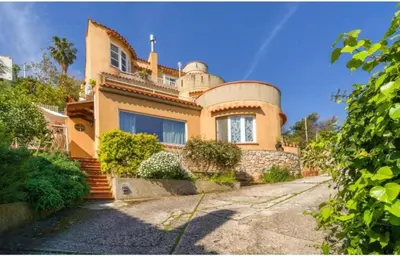 a large yellow house with a turret at La Conca D'Oro in Palermo