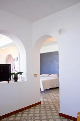 a bedroom with white walls and a bed in a room at La Conca D'Oro in Palermo