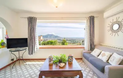 a living room with a couch and a large window at La Conca D'Oro in Palermo