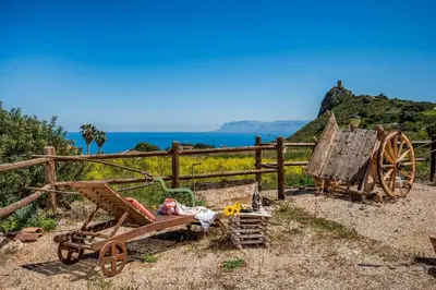 a wooden cart sitting next to a fence at Villa Elena 2 Km from the Natural Reserve of Zingaro in Scopello